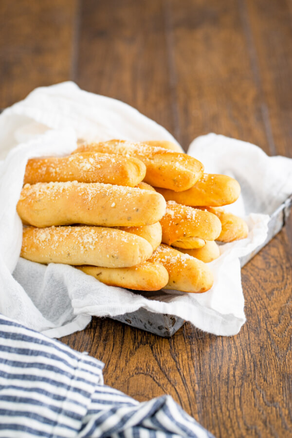 finished bread sticks in basket with striped linen cloth