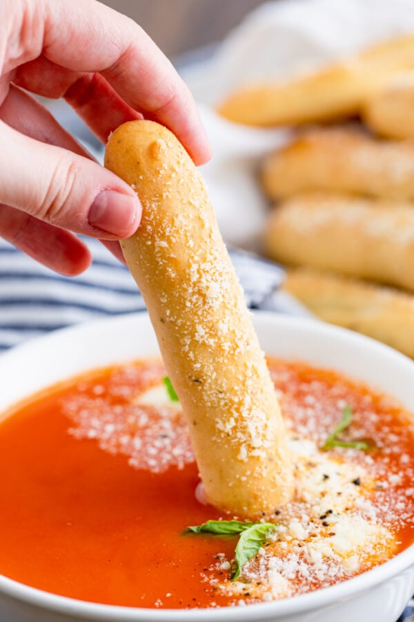 breadstick being dipped into marinara sauce