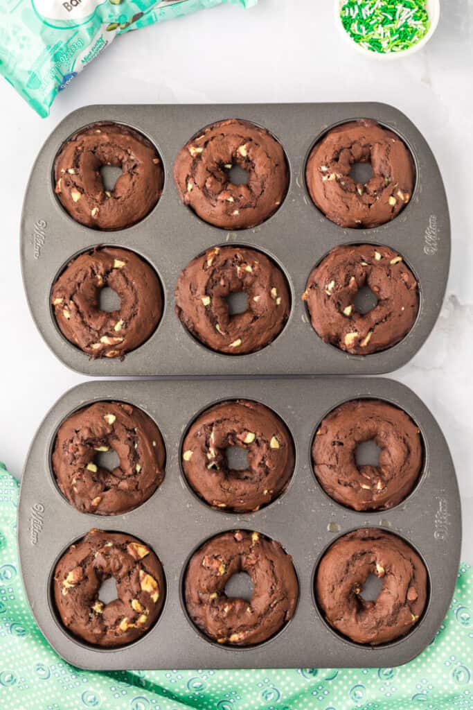 Freshly baked Chocolate Mint Donuts cooling in the donut pans