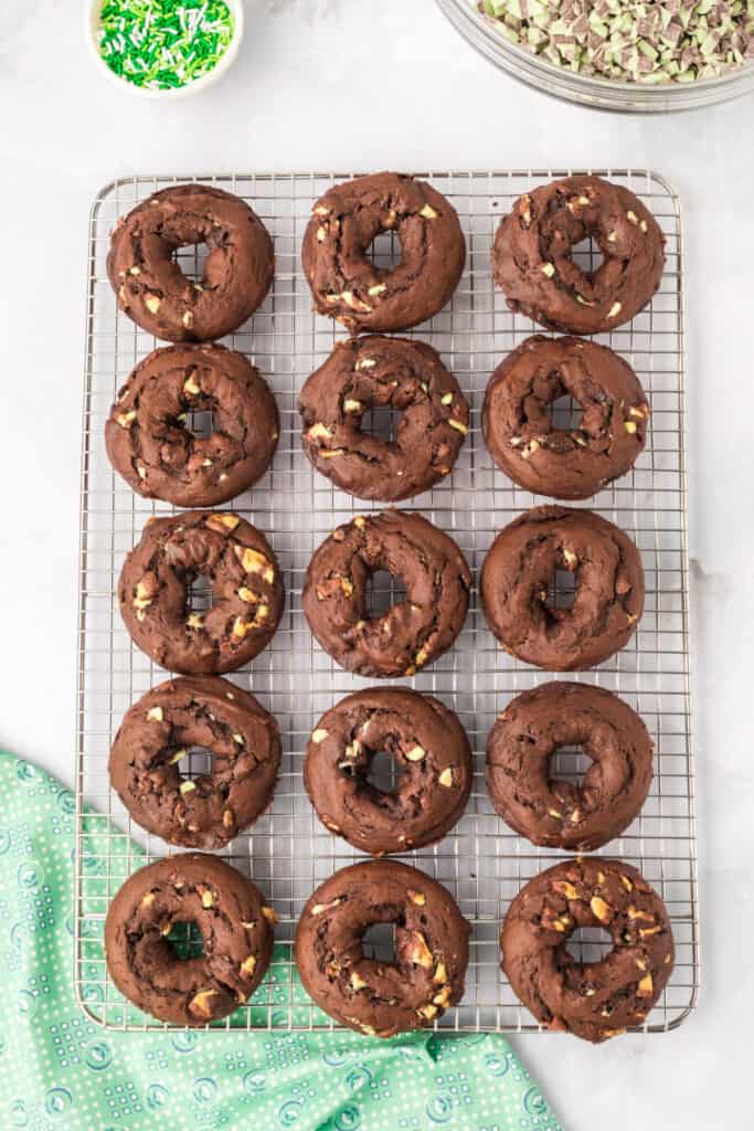 Homemade Chocolate Mint Donuts cooling on a wire rack after baking