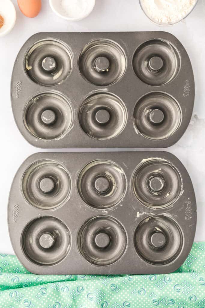 Greased donut pans prepared for baking Chocolate Mint Donuts