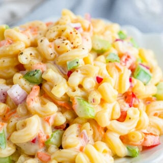 closeup of a white bowl filled with macaroni salad