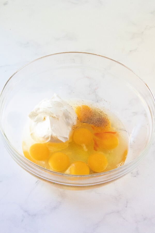 eggs, sour cream, salt, and pepper sauce in mixing bowl