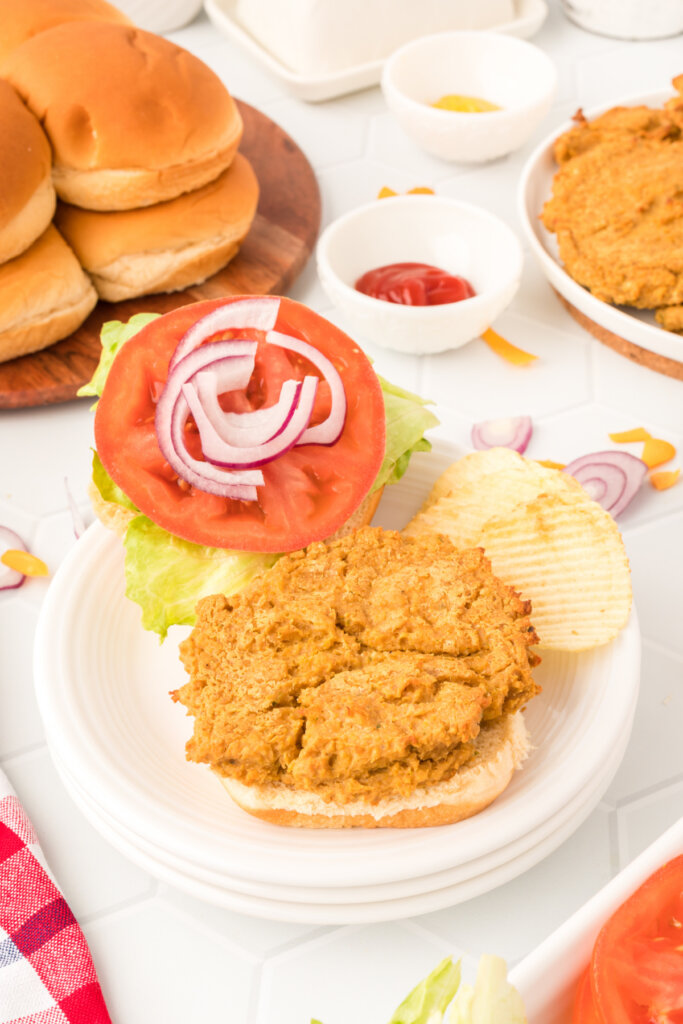 butter bean burger patty on bun with lettuce tomato and onions