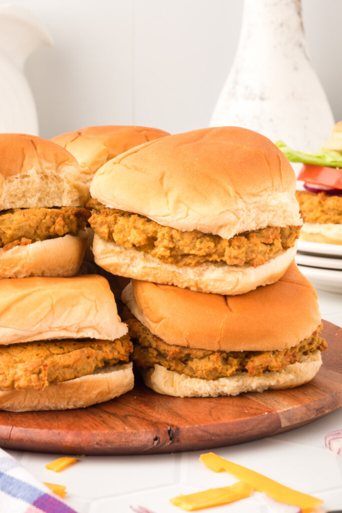 butter bean burgers stacked on wooden cutting board