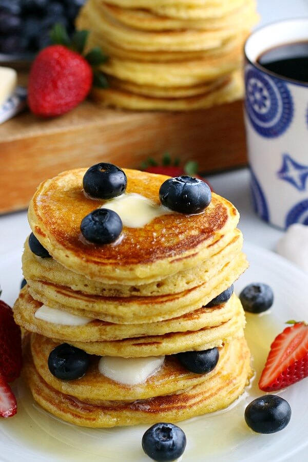 A stack of cornmeal cakes with blueberries.