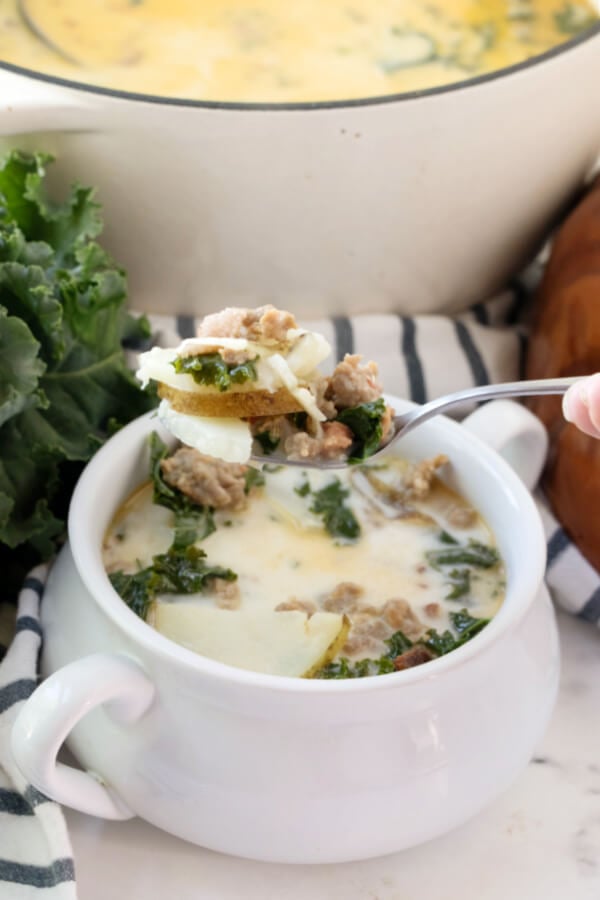 spoonful of Zuppa Toscana soup over bowl