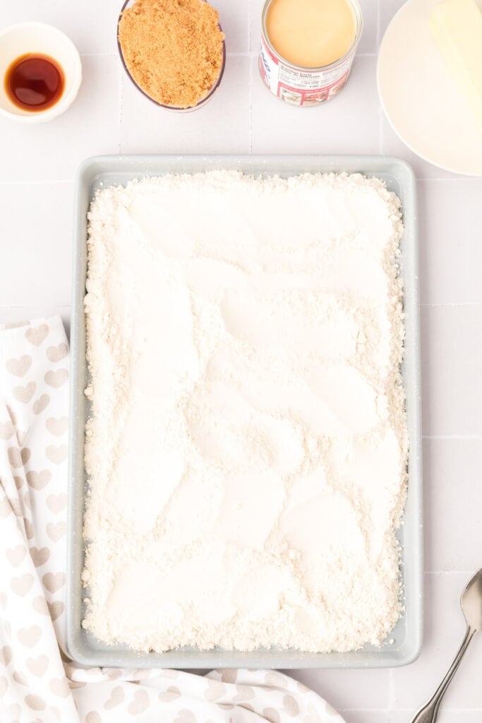Baking sheet spread with flour ready to be baked to make it safe for edible cookie dough.
