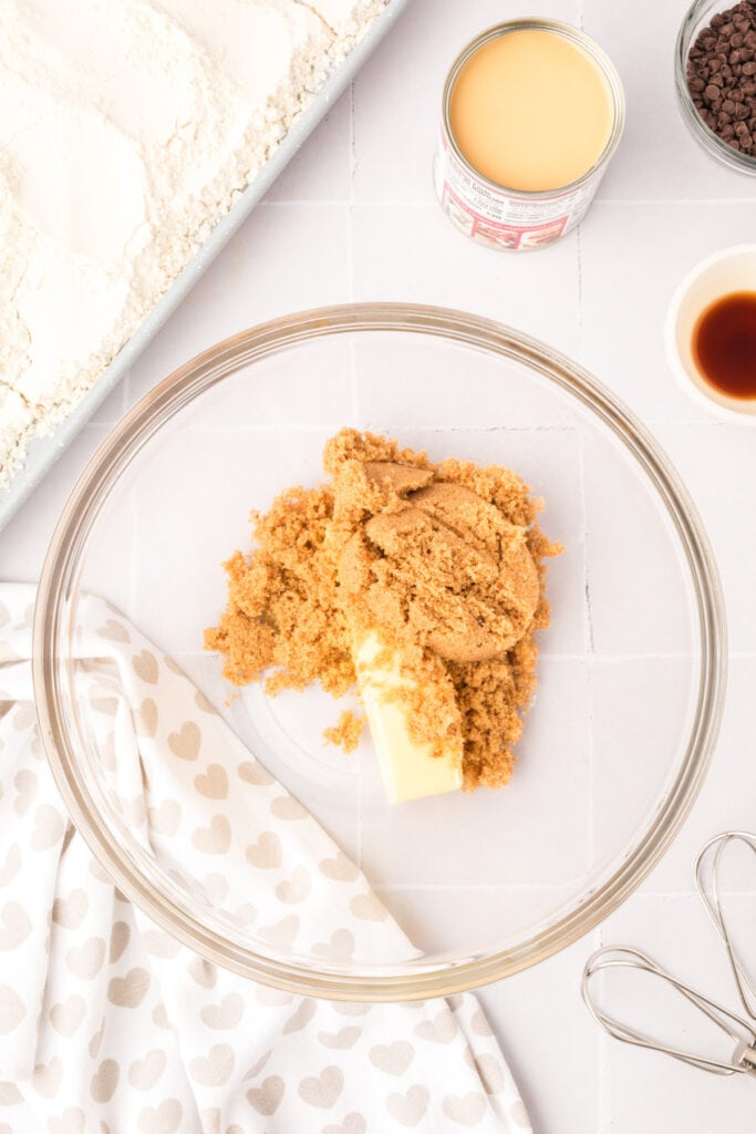 Mixing bowl with softened butter and brown sugar before creaming together.