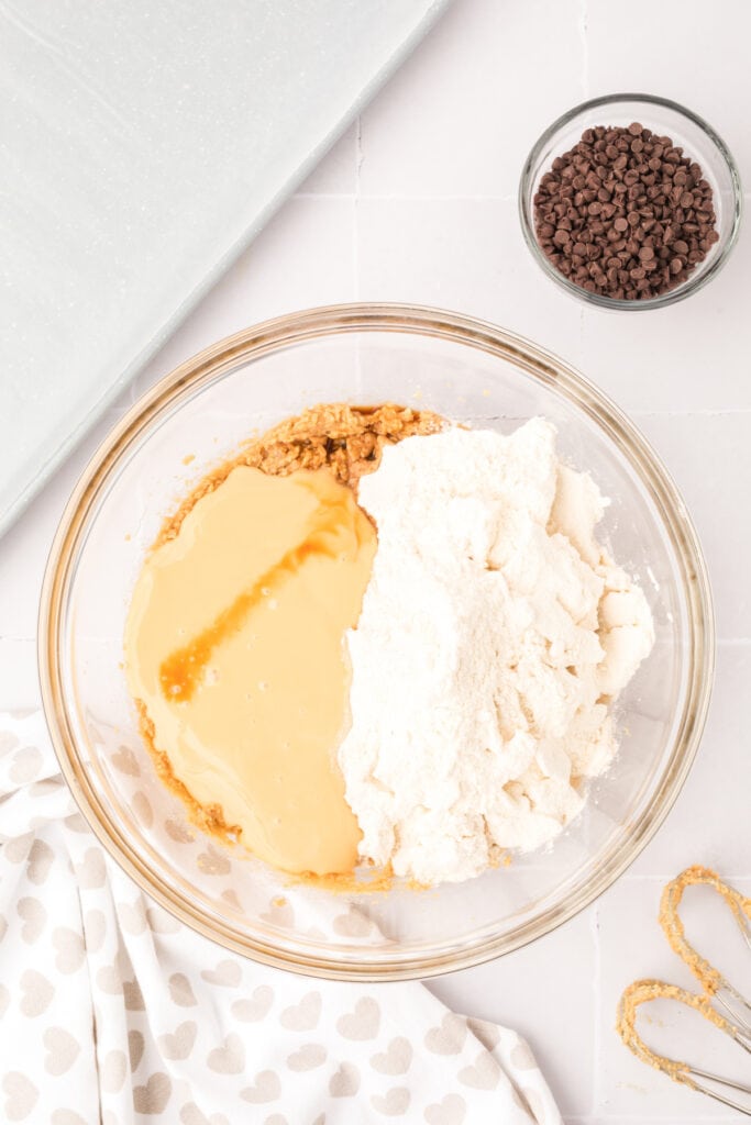 Mixing bowl with flour and sweetened condensed milk added to the creamed butter and sugar mixture.