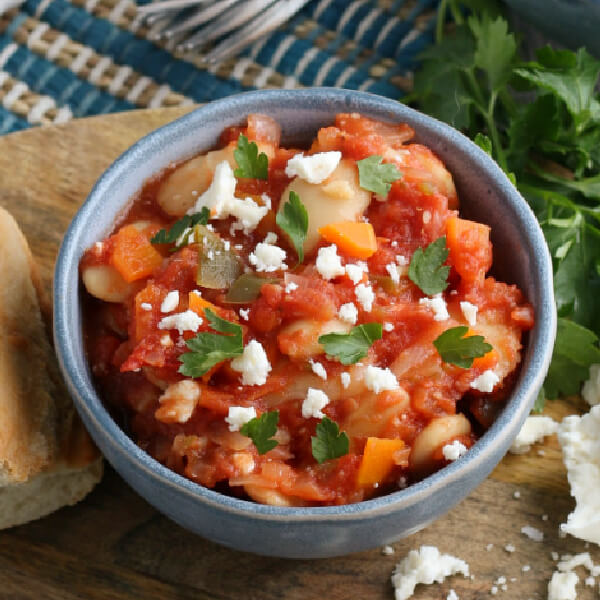 blue bowl with Greek Baked Beans topped with Feta cheese