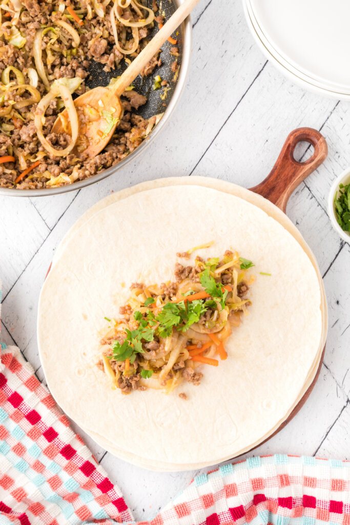 pork burrito filling on tortilla before being rolled up