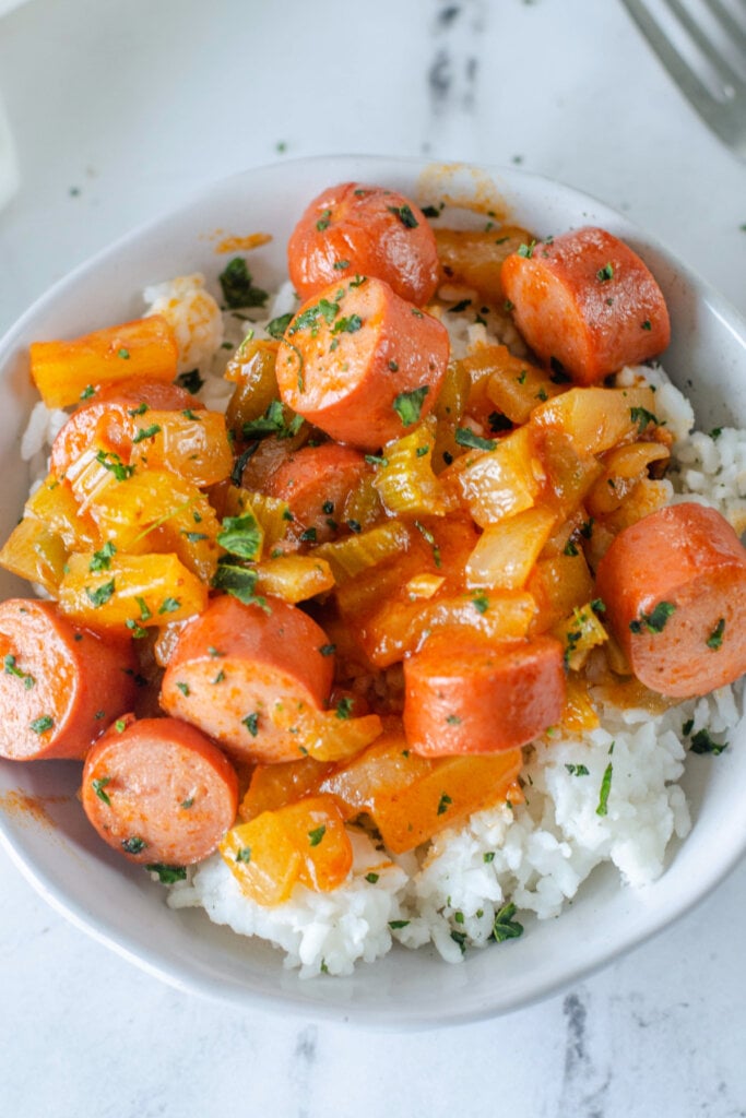 bowl with sweet and sour hot dogs over rice