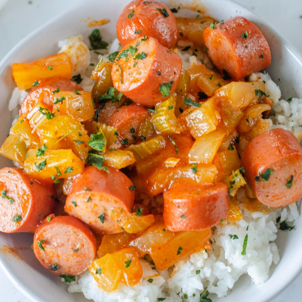 closeup of sweet and sour hot dogs over rice