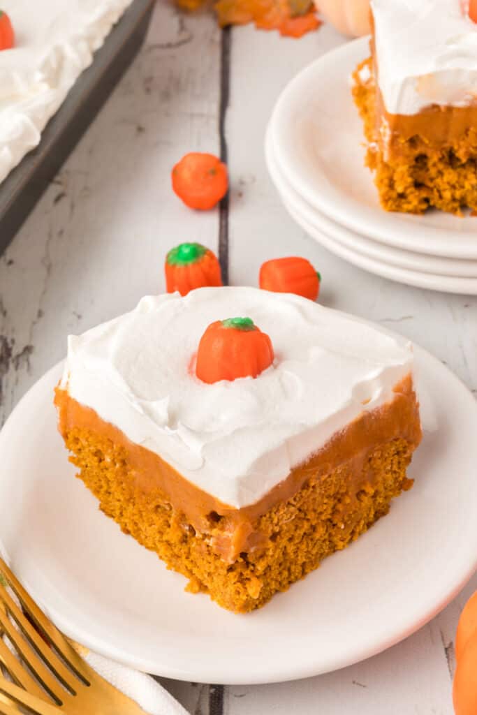 Plated slice of pumpkin pudding cake with candy pumpkins and fall setup