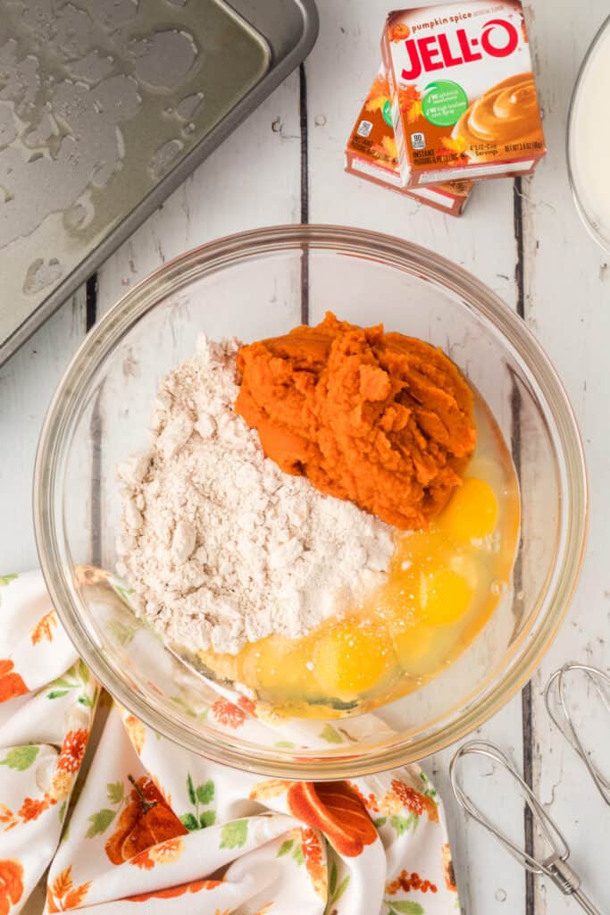 Mixing bowl with eggs, pumpkin, and spice cake mix ready to be blended