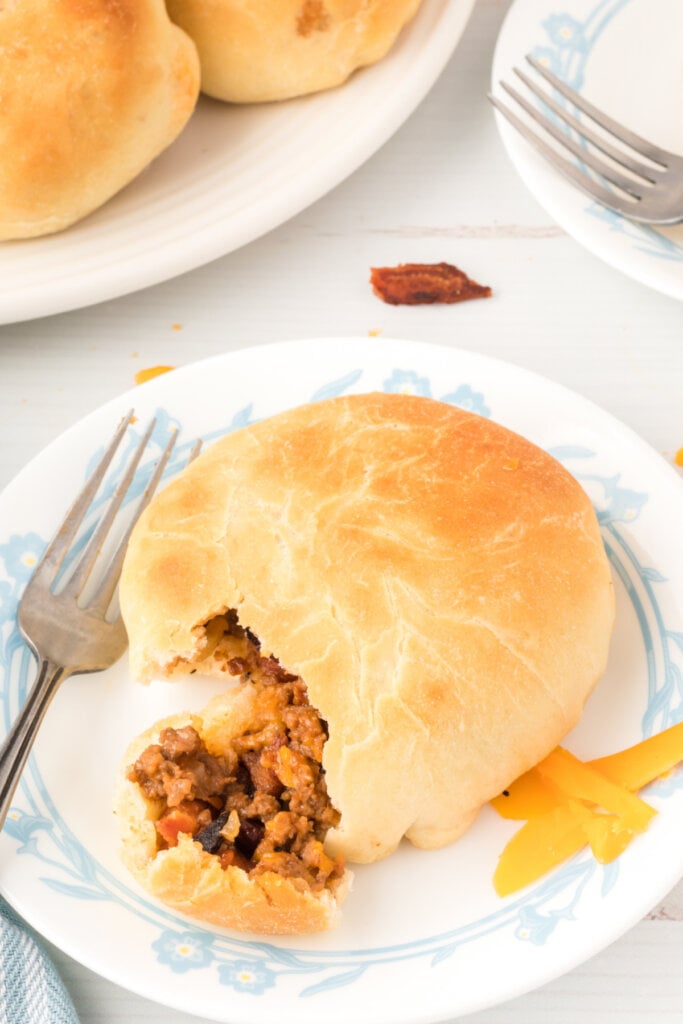 bbq bacon cheeseburger bun on plate with fork