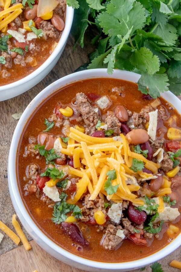 Taco Soup is a hearty and satisfying recipe with plenty of ground beef, beans, corn, and tomatoes in a zesty taco flavored broth. closeup bowl of soup