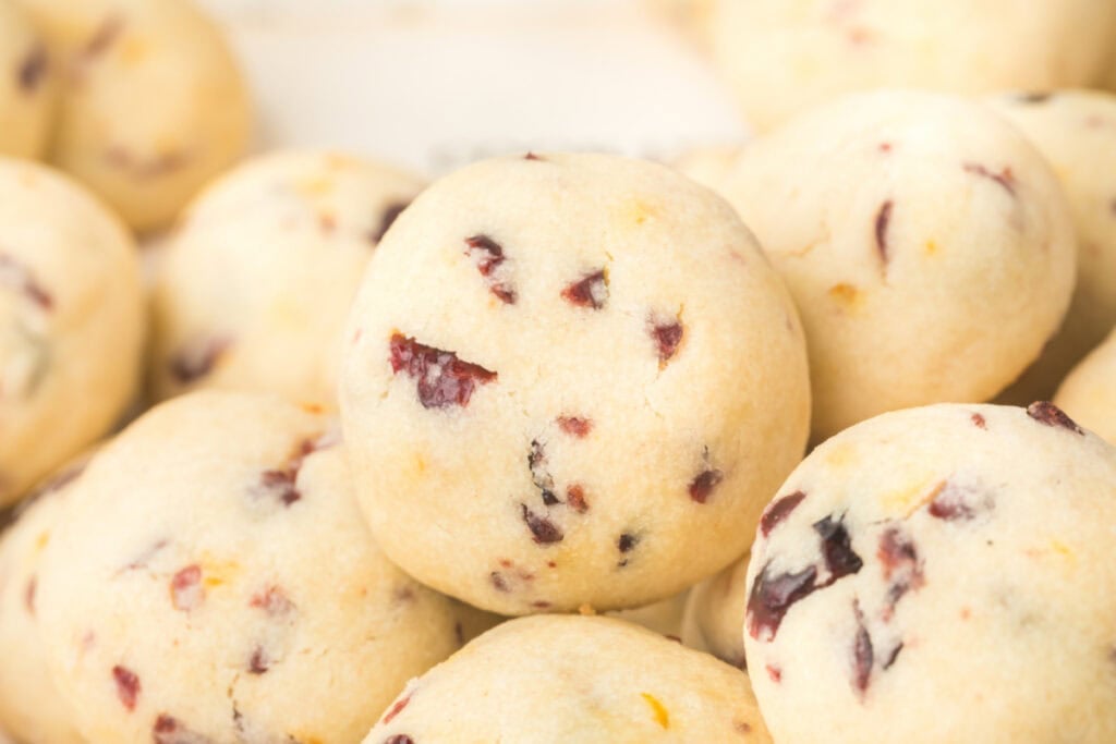 Pile of Cranberry Orange Christmas Sandies cookies .