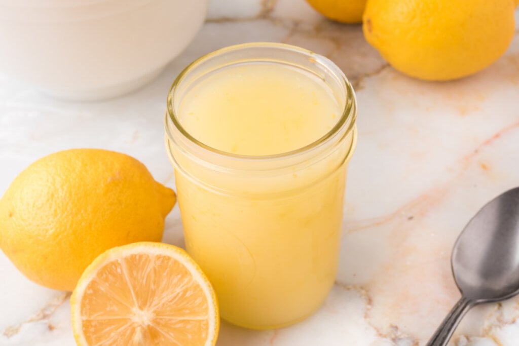 lemon sauce in jar with lemons on the side