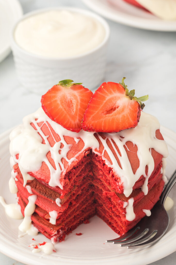 red velvet pancakes stacked with cream cheese icing