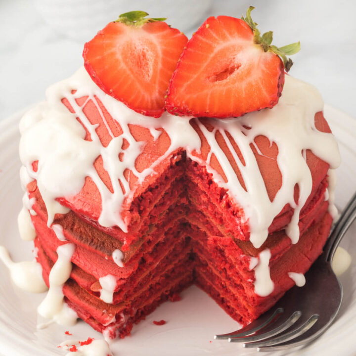 stack of red velvet pancake with cut strawberry on top