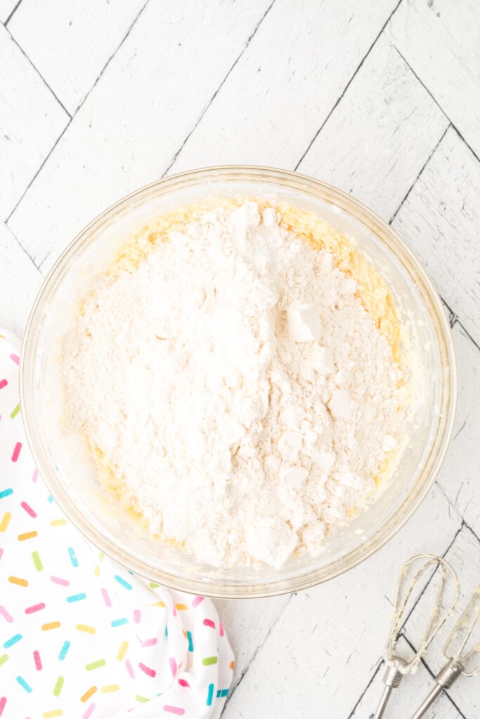 Dry ingredients added to the creamed butter, sugar, and egg mixture in a large mixing bowl.