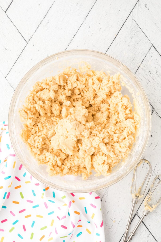 Cookie dough coming together after mixing wet and dry ingredients for soft sugar cookies.