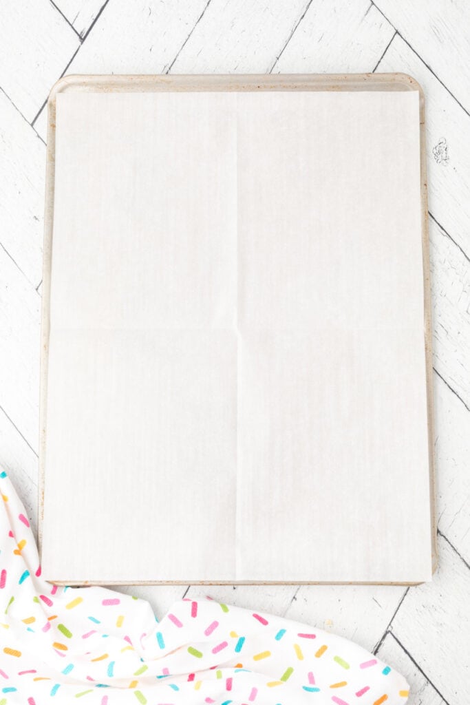 Baking sheet lined with parchment paper, ready for soft sugar cookies.