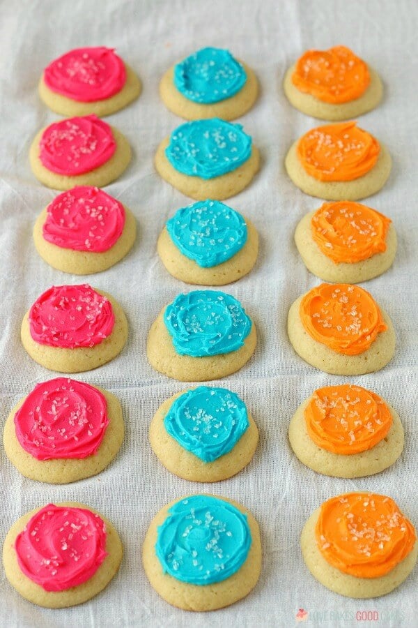 Soft Sugar Cookies laying on a cloth in different colors.