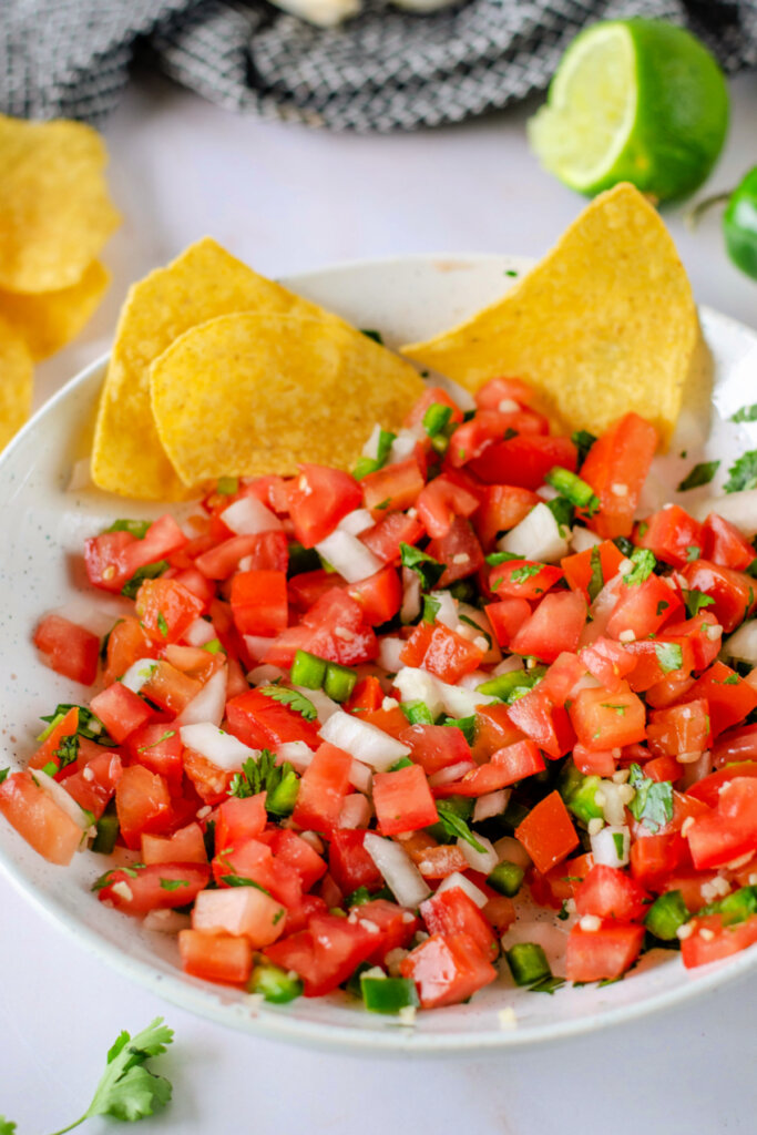 pico de gallo in bowl with a couple of tortilla chips