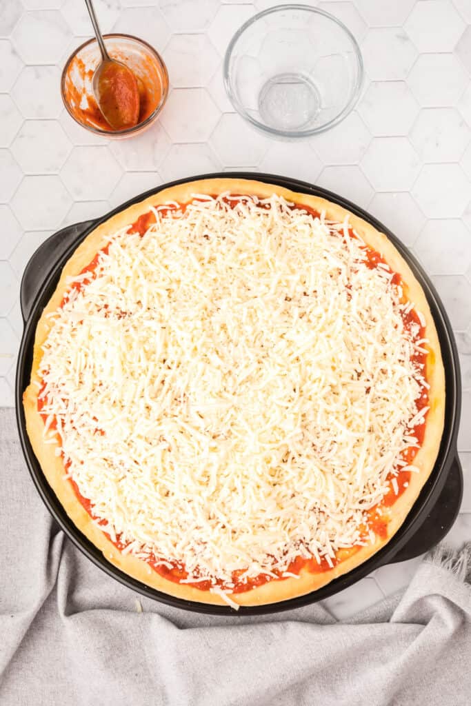 Homemade cheese pizza topped with pizza sauce and mozzarella cheese on Bread Machine Pizza Dough