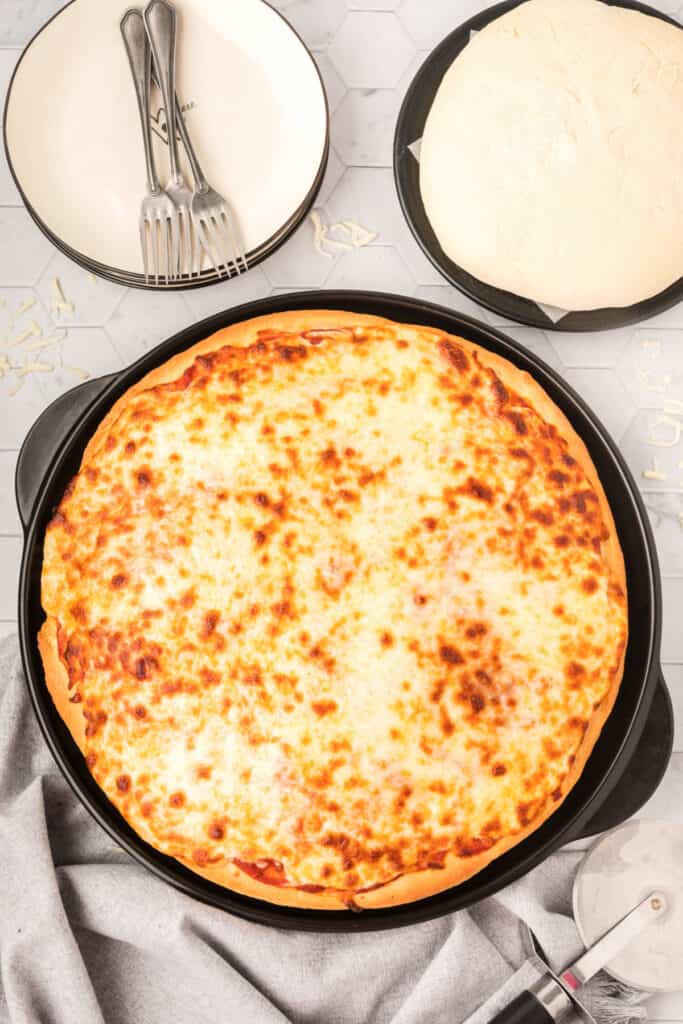 Baked homemade cheese pizza with golden melted mozzarella on Bread Machine Pizza Dough