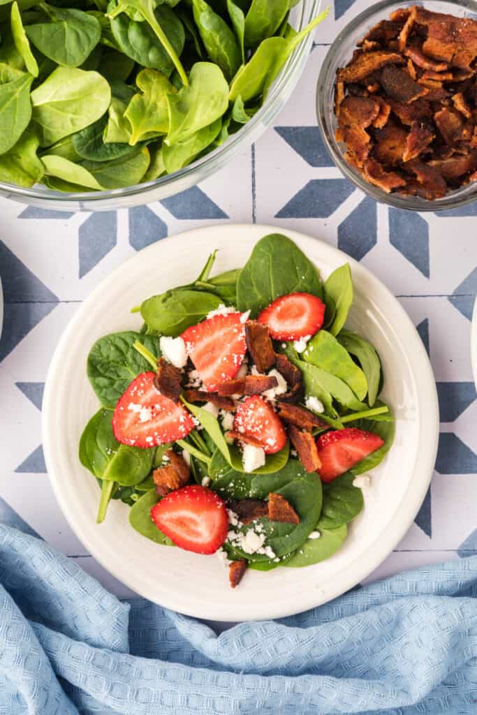 spinach, strawberries, and feta topped with crispy bacon pieces for strawberry spinach salad