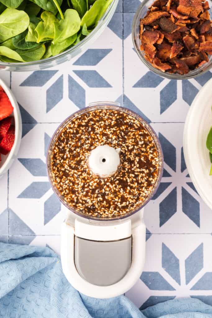 blended balsamic poppy seed dressing with sesame seeds and poppy seeds in a food processor