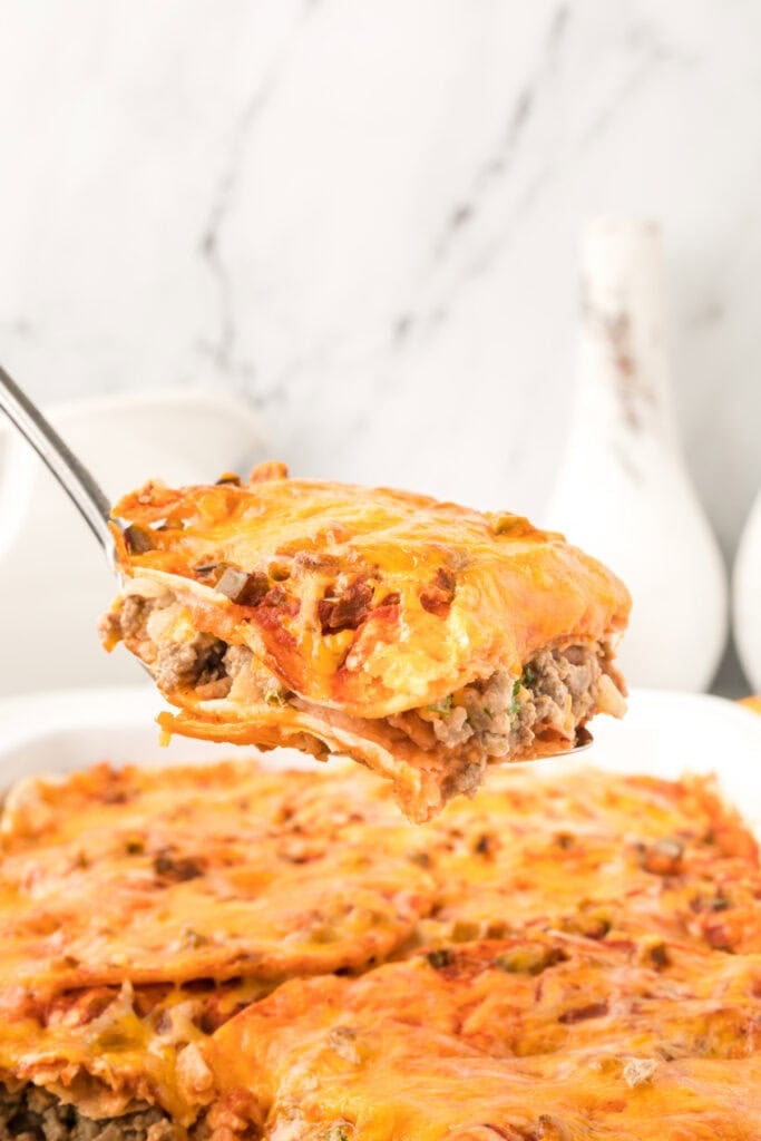 slice of beef and bean enchilada casserole lifted on a spatula