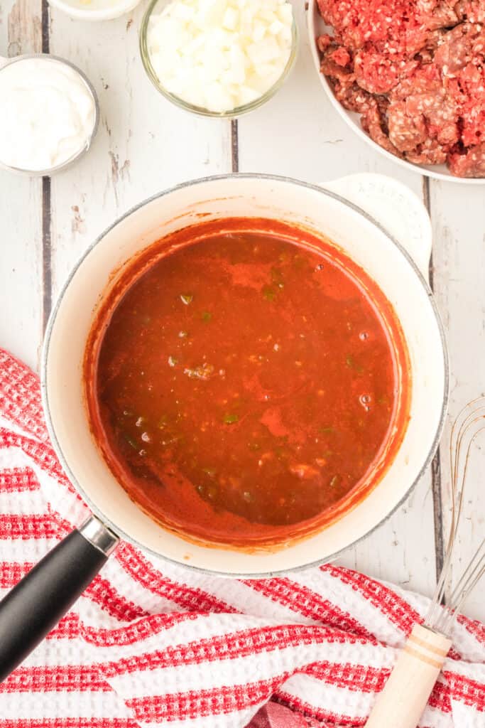 cooked enchilada sauce in a saucepan with a smooth red texture