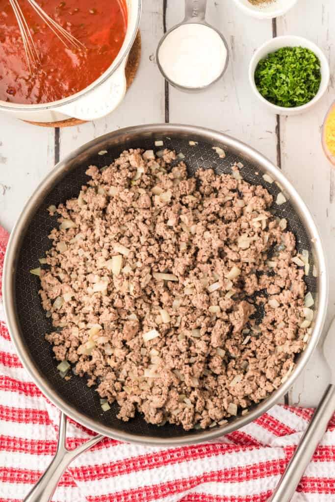 browned ground beef and onions fully cooked in a skillet