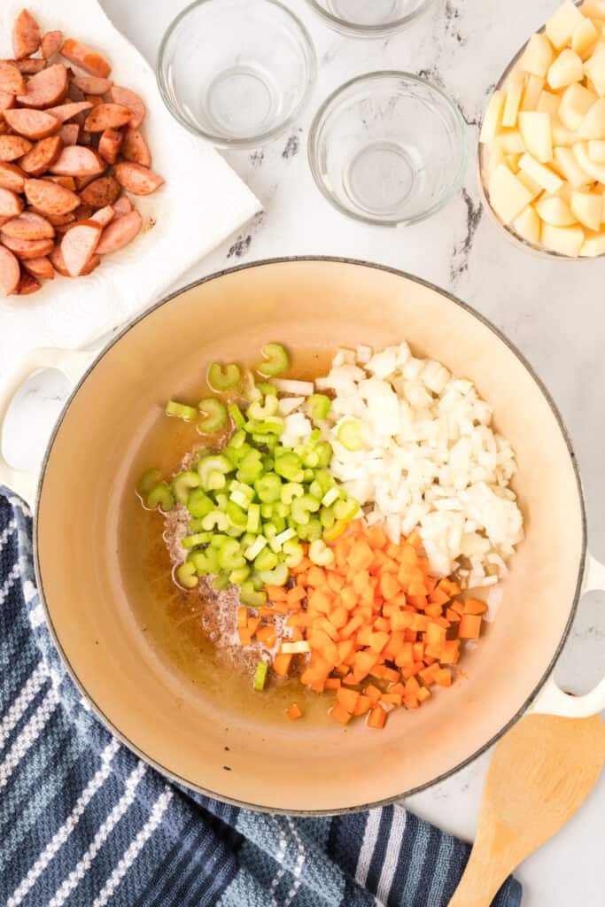 Chopped celery, onion, and carrots added to the pot with melted butter.