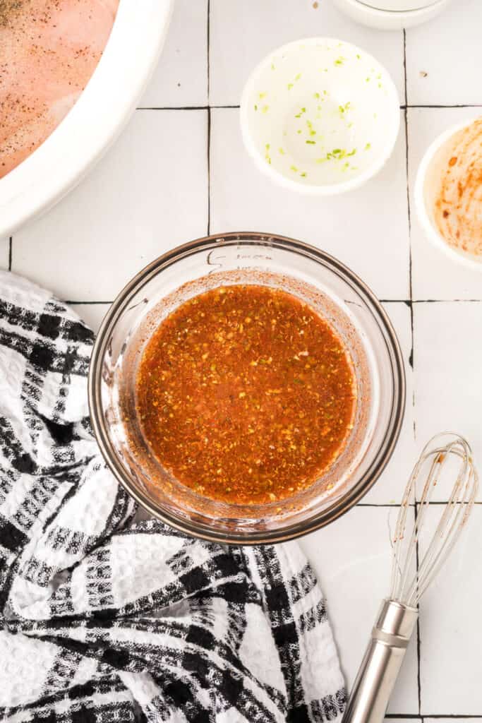 Chipotle lime sauce mixed in a glass bowl with a whisk nearby