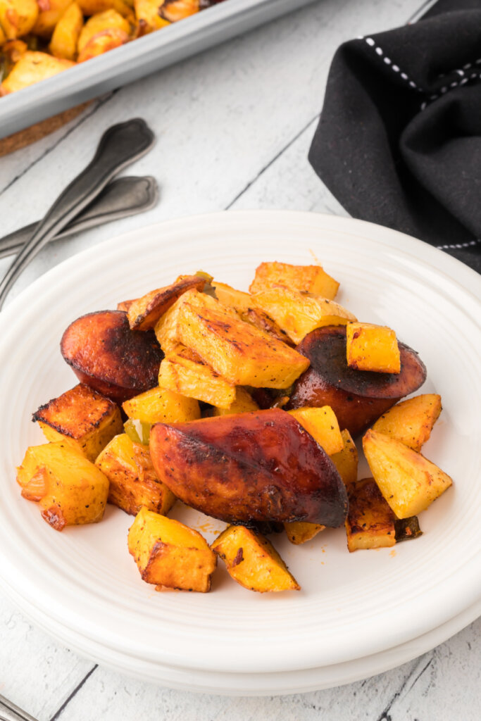 sheet pan sausage and potatoes on white plate