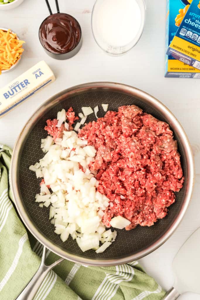 raw ground beef and chopped onion in a skillet for BBQ Beefy Mac and Cheese