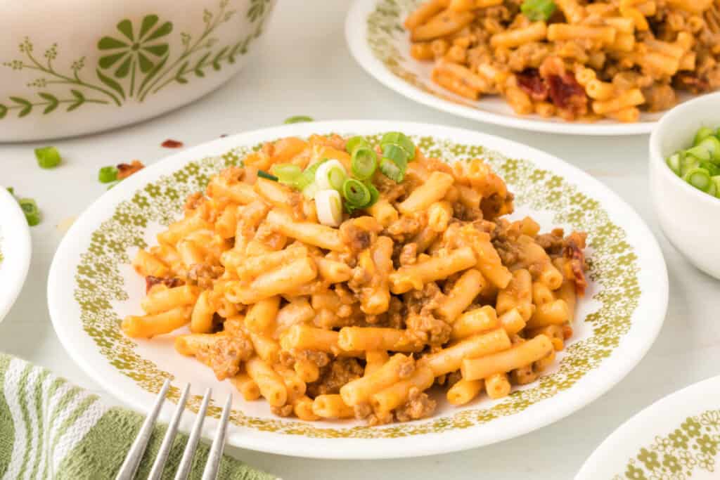 BBQ Beefy Mac and Cheese on a plate with ground beef and green onions garnish