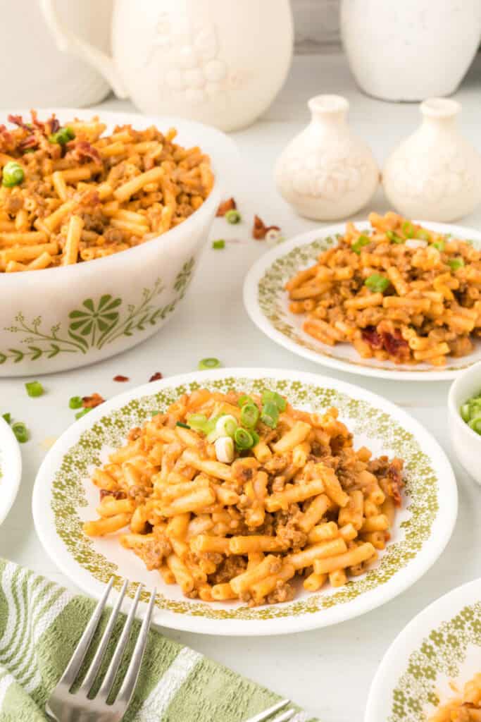 BBQ Beefy Mac and Cheese served family-style with multiple plates and a serving bowl