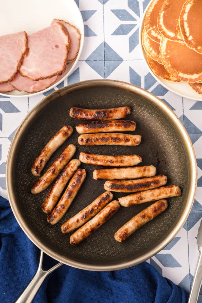 Cooked breakfast sausage links in skillet for Breakfast Kabobs and Mini Pancakes