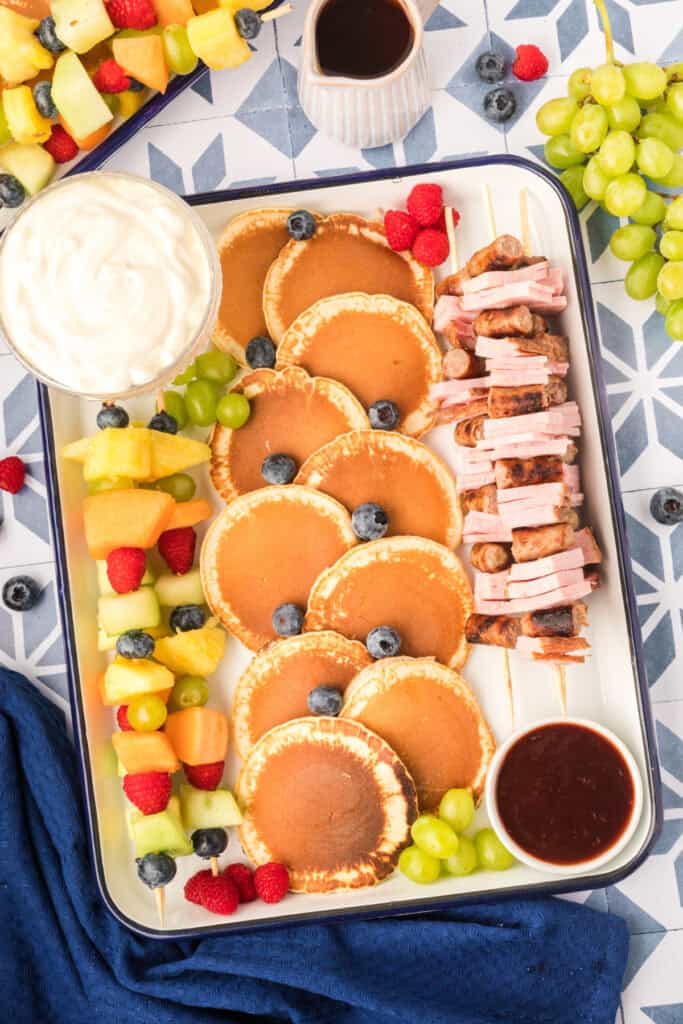Breakfast Kabobs and Mini Pancakes platter with fruit skewers, yogurt dip, sausage kabobs, and mini pancakes