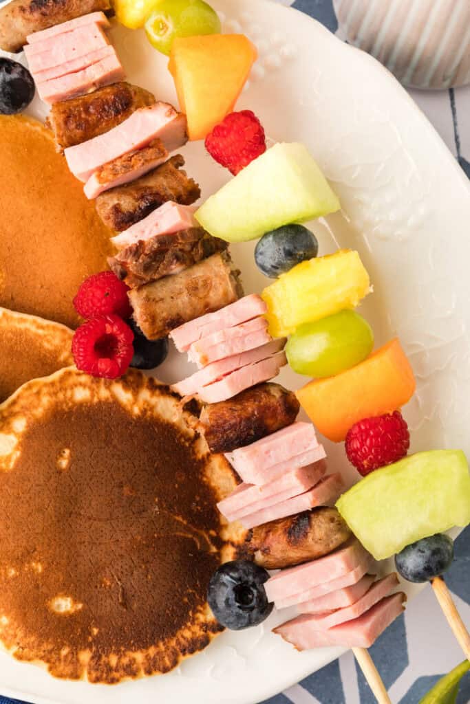 Breakfast Kabobs and Mini Pancakes brunch platter with dipping sauce and fresh fruit