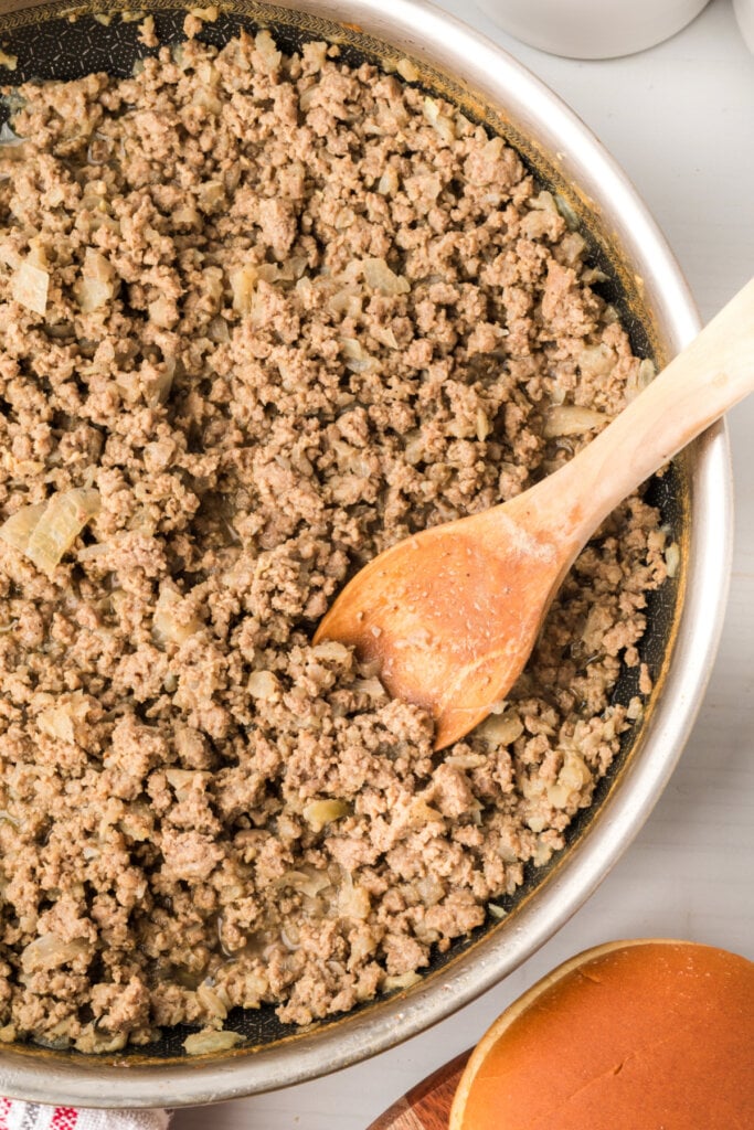 maid-rites loose meat sandwich filling in a skillet with a wooden spoon