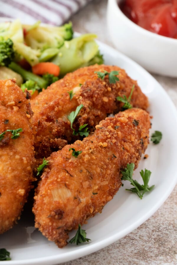 italian chicken strips on plate with veggies