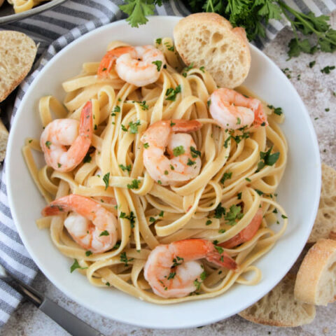 closeup of shrimp scampi pasta in white bowl